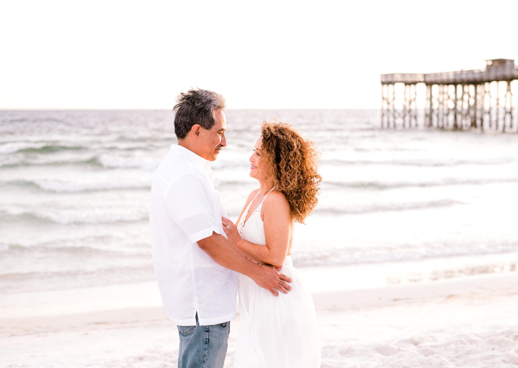 Image of a couple on the beach embracing happily.