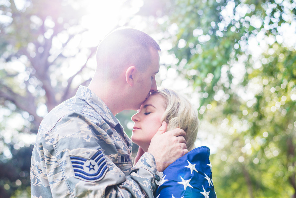An image of an Air Force member kissing a woman on the forehead.
